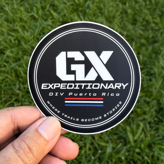 Sticker with 'GX Expeditionary' logo held over grass